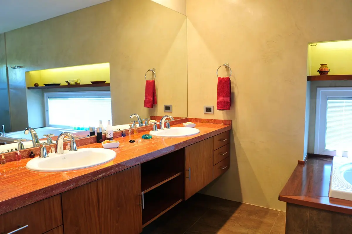 Banheiro moderno com duas cubas e bancadas de terracota — projeto Casa GTT, por Estudio Gamboa