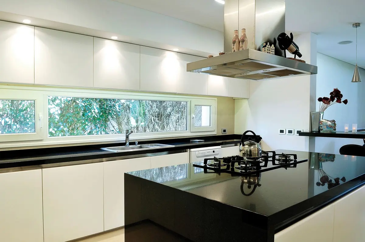 Cozinha moderna com ilha central e amplas janelas — projeto Casa GTT, por Estudio Gamboa