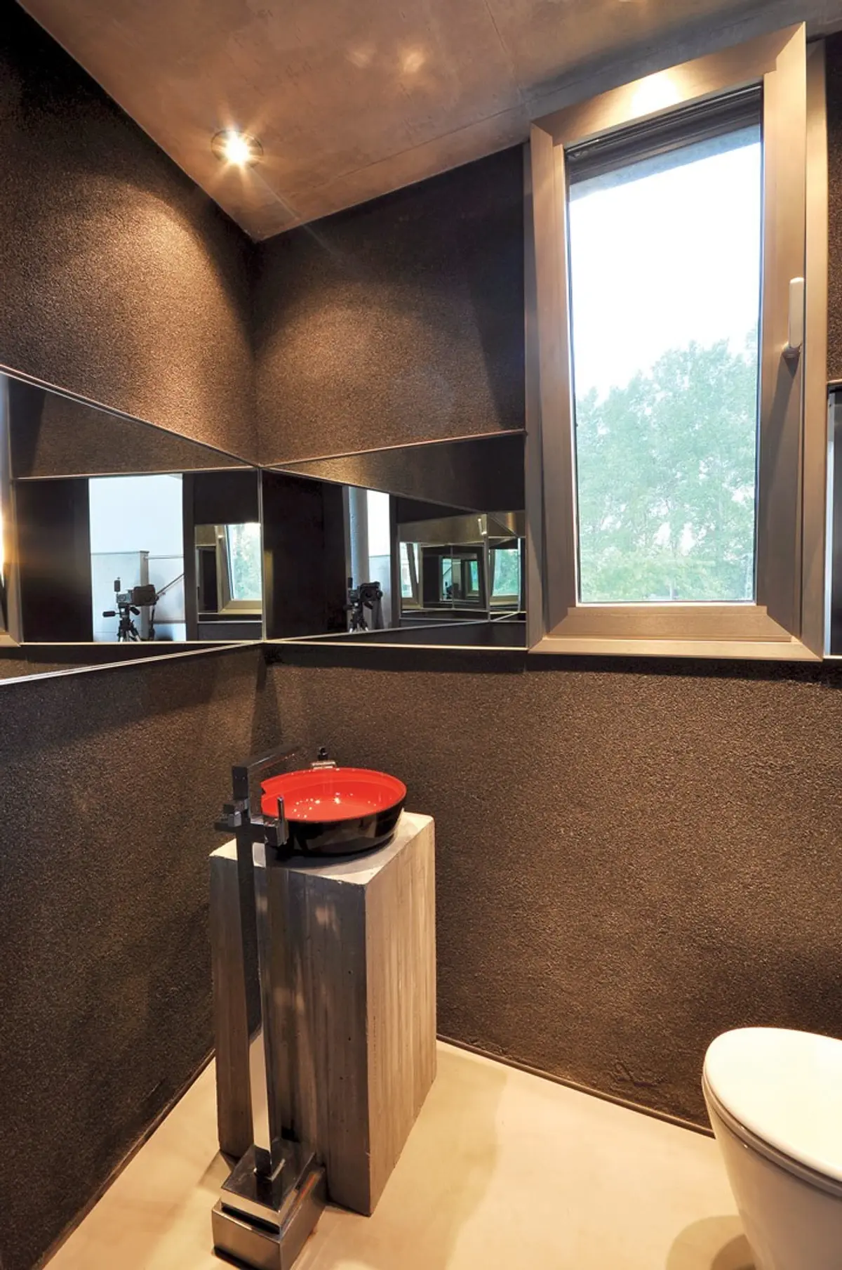 Baño moderno con lavabo rojo, espejos facetados y paredes texturizadas — proyecto Casa MMP, por Estudio Gamboa