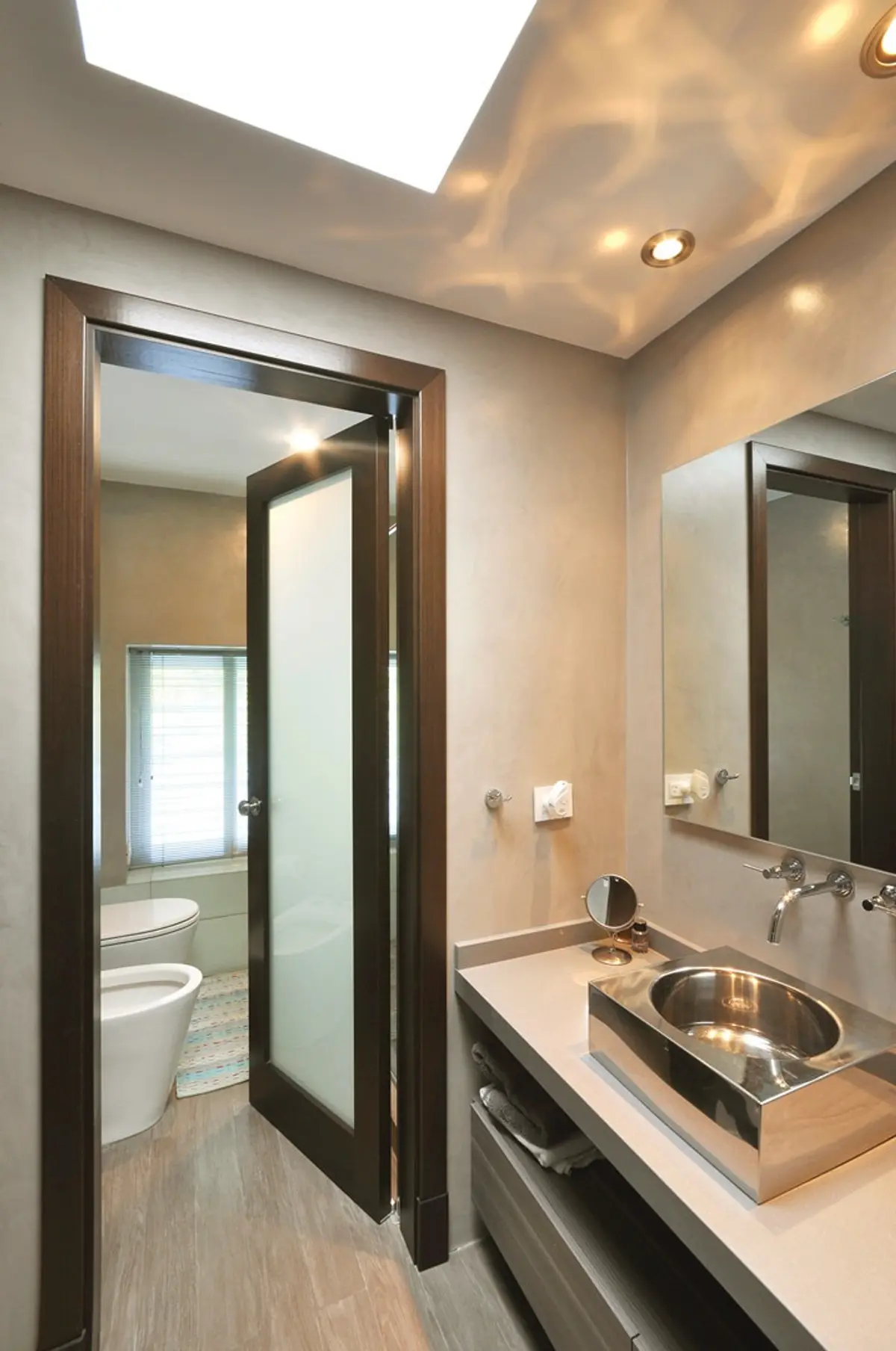 Baño moderno con bacha rectangular de acero inoxidable y puerta de vidrio esmerilado — proyecto Casa MMP, por Estudio Gamboa