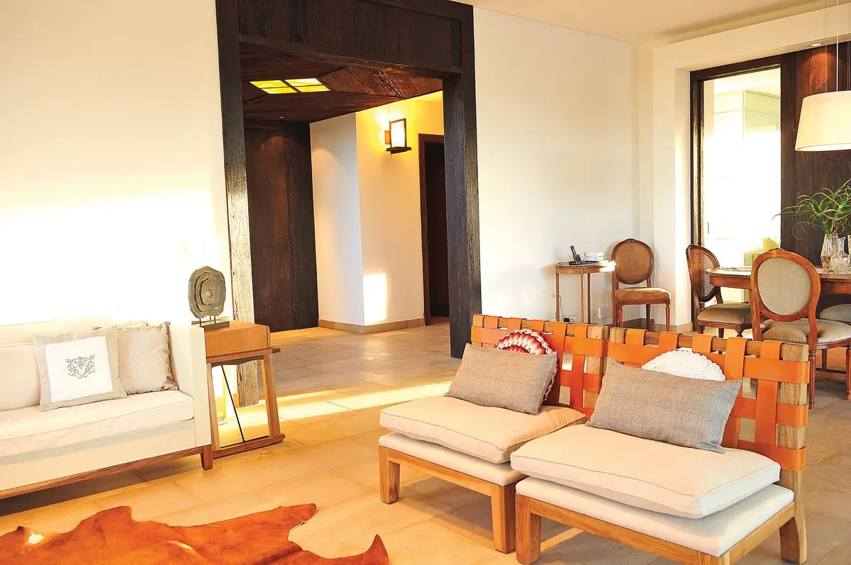 Living rústico con vigas de madera y muebles de mimbre — proyecto Casa Tigre, por Estudio Gamboa, en Tigre