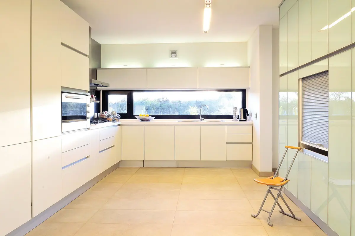 Cozinha moderna branca com armários embutidos e janela grande — projeto Casa Tigre, por Estudio Gamboa, em Tigre