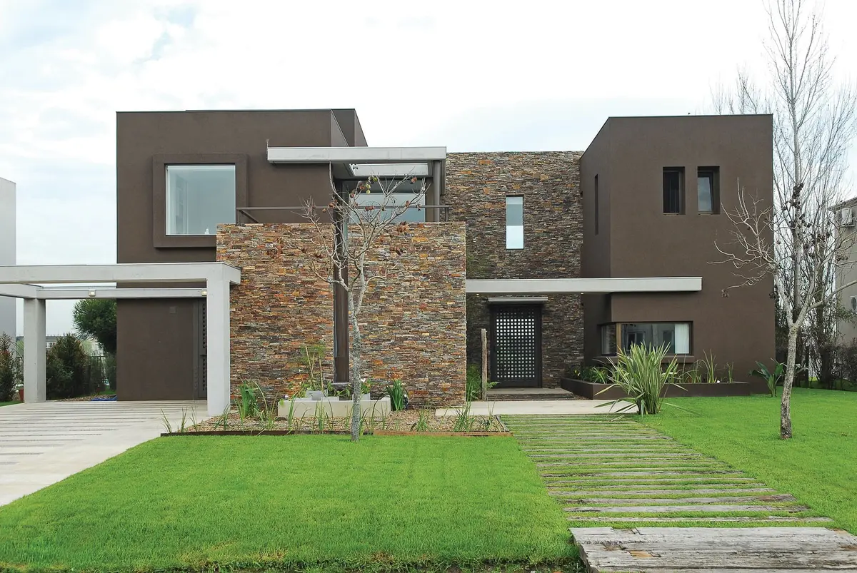 Fachada moderna con piedra apilada y estuco marrón — proyecto Casa RFM, por Estudio Gamboa
