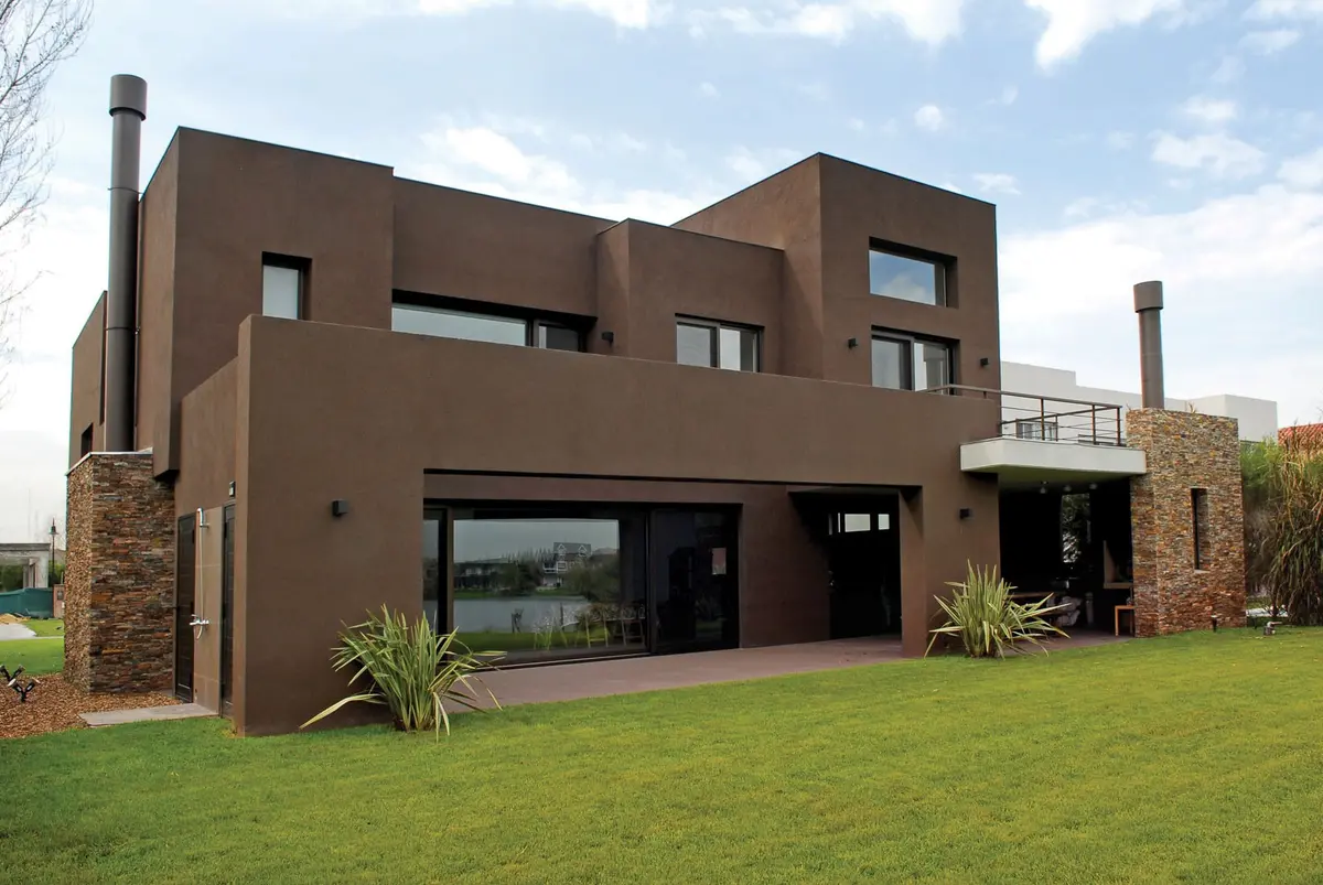 Fachada moderna marrom com pedra e janelas amplas — projeto Casa RFM, por Estudio Gamboa