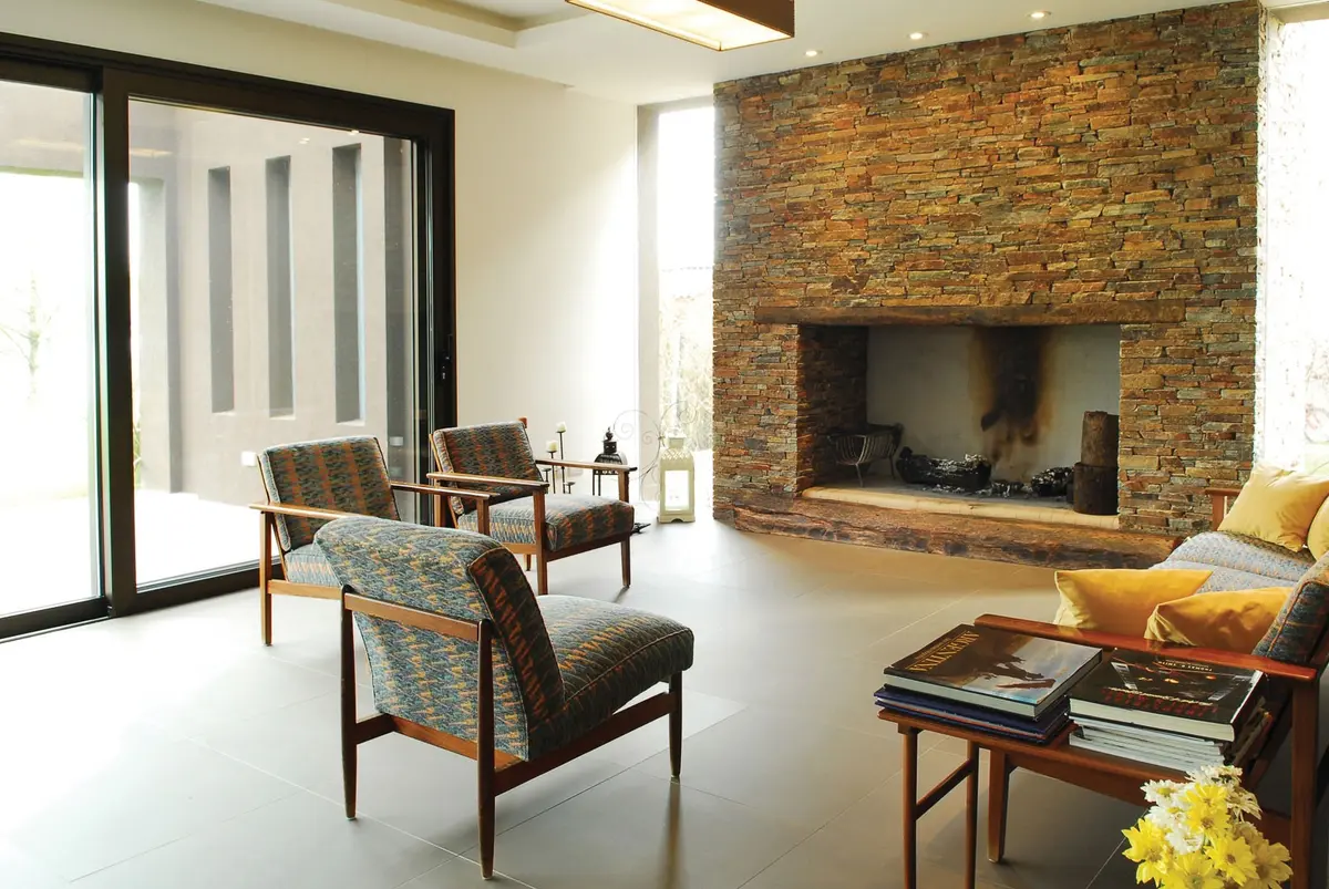 Living moderno con chimenea de ladrillos y grandes ventanales — proyecto Casa RFM, por Estudio Gamboa
