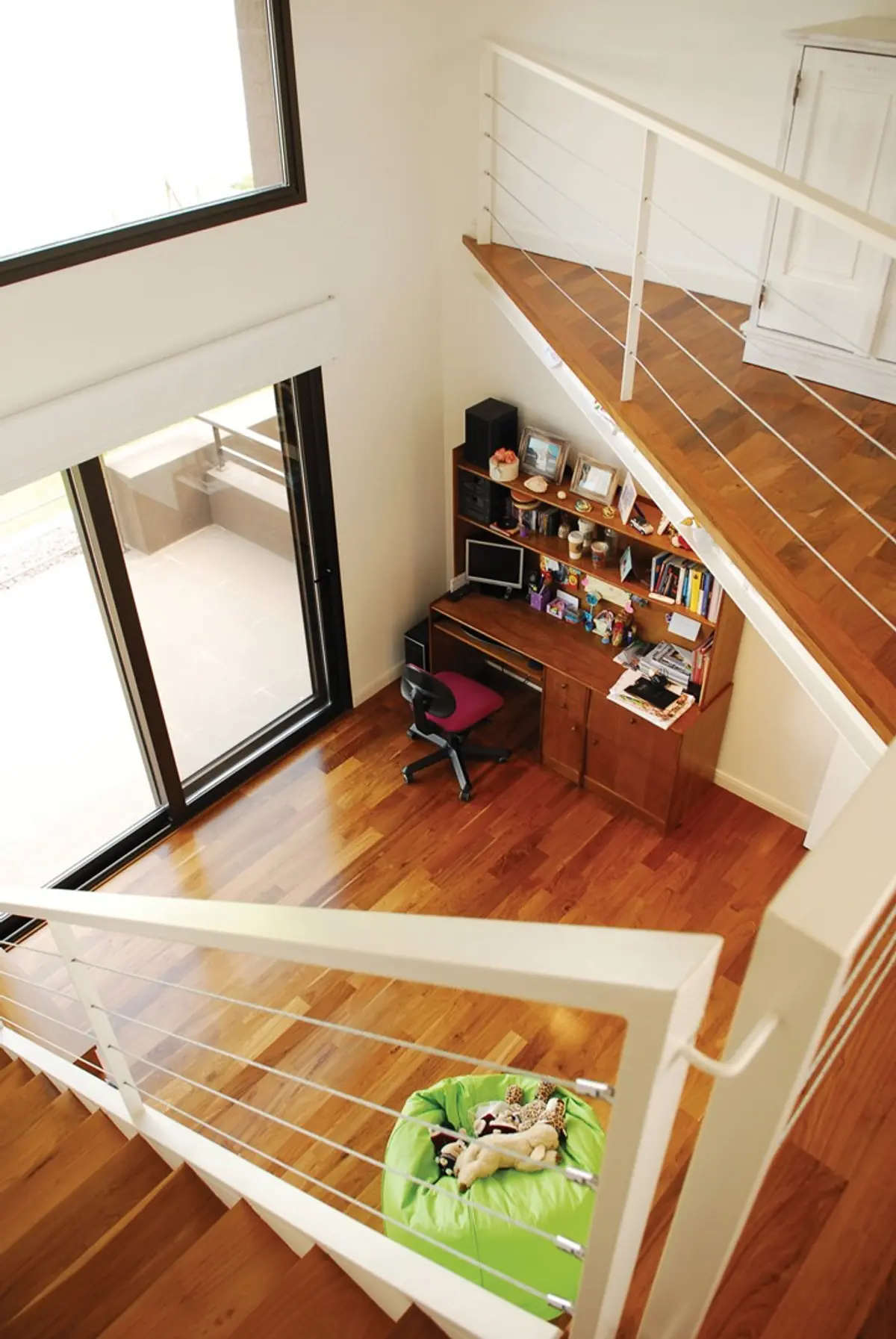 Escalera flotante moderna con oficina integrada y suelo de madera — proyecto Casa RFM, por Estudio Gamboa