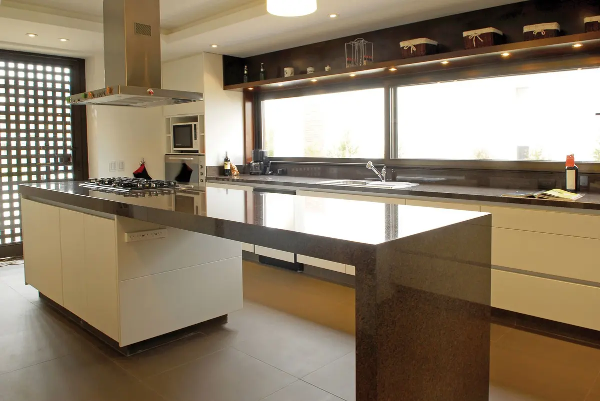 Cozinha moderna com ilha grande e janelas do chão ao teto — projeto Casa RFM, por Estudio Gamboa