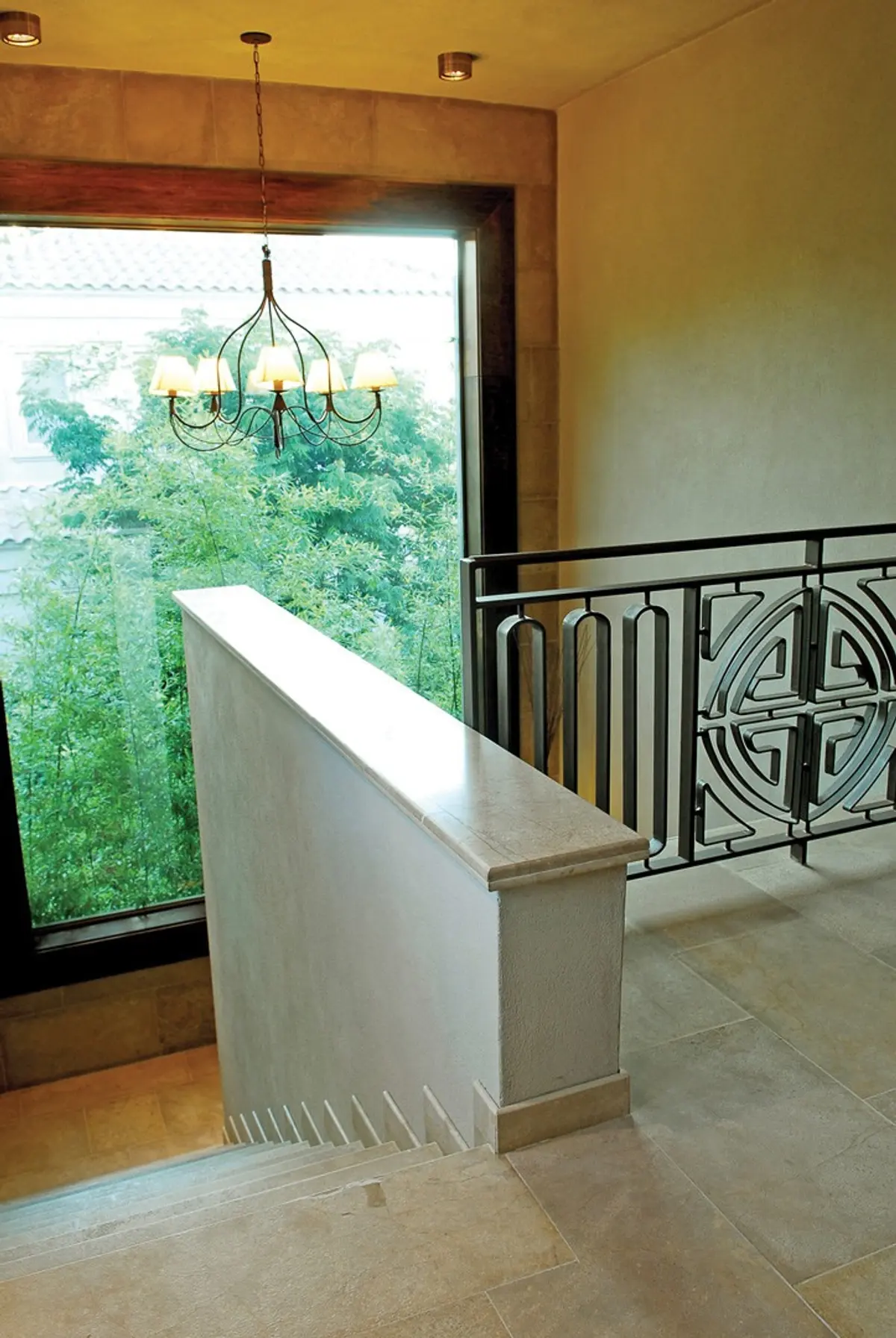 escalera interior con ventana grande y araña clásica — proyecto Casa FGR, por Estudio Gamboa