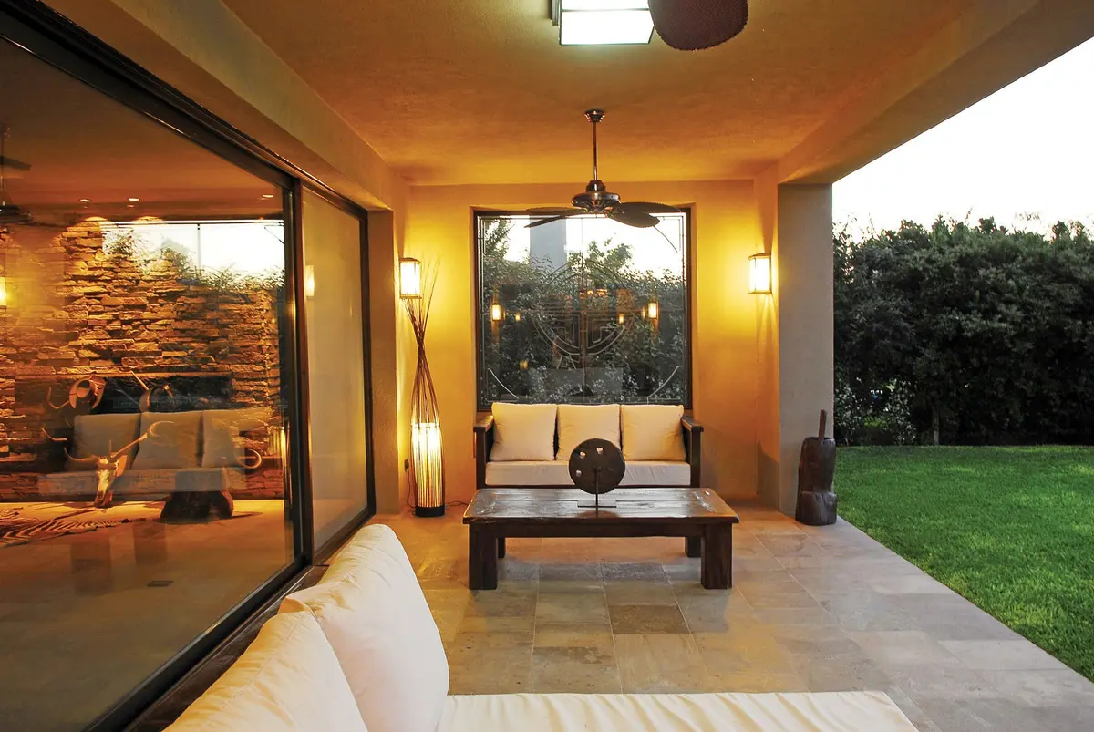 Pátio moderno com sala de estar externa e jardim exuberante — projeto Casa FGR, por Estudio Gamboa