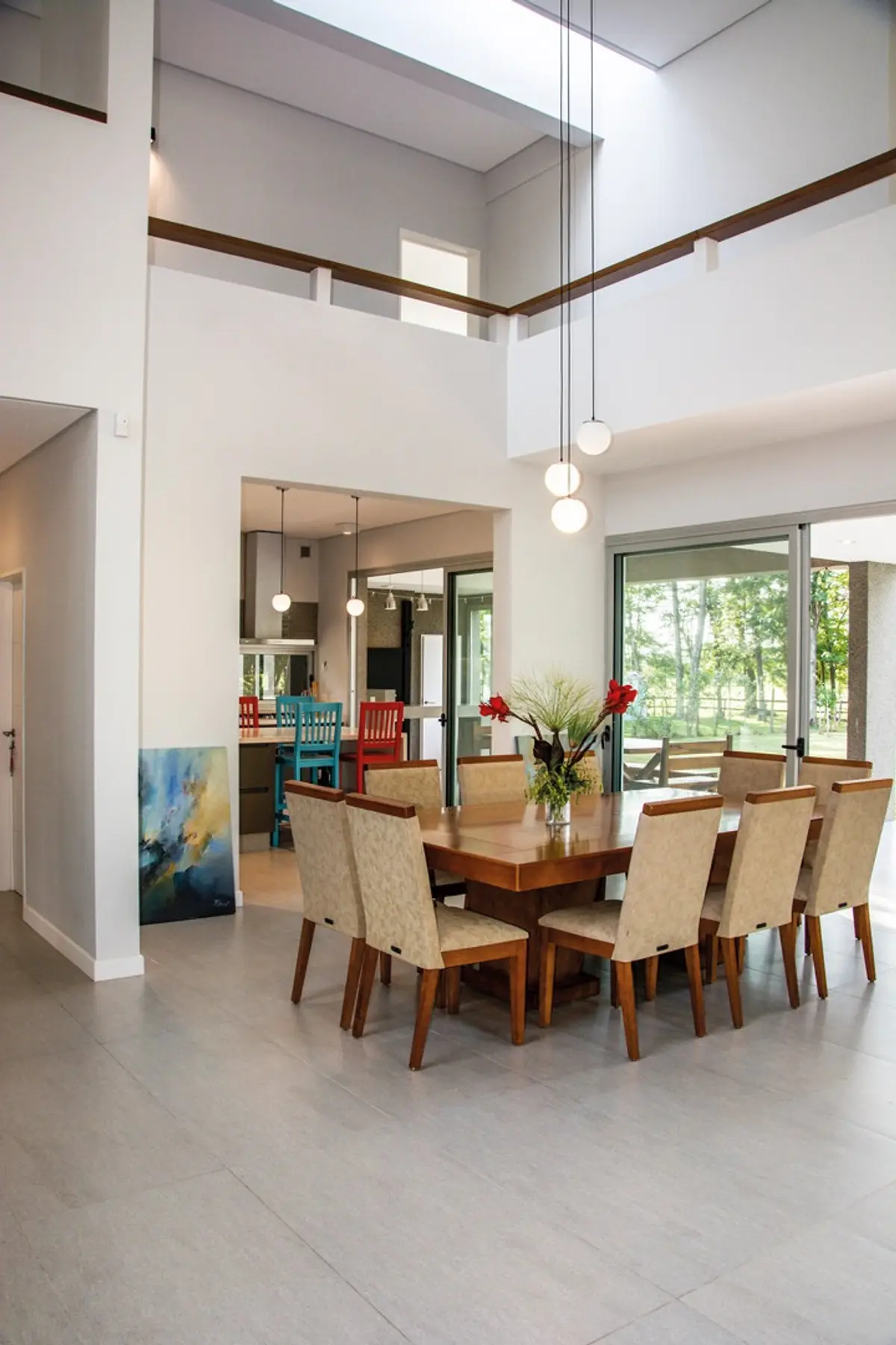 Comedor moderno con doble altura, mesa de madera y sillas beige — proyecto Casa 18, por Parrado Arquitectura