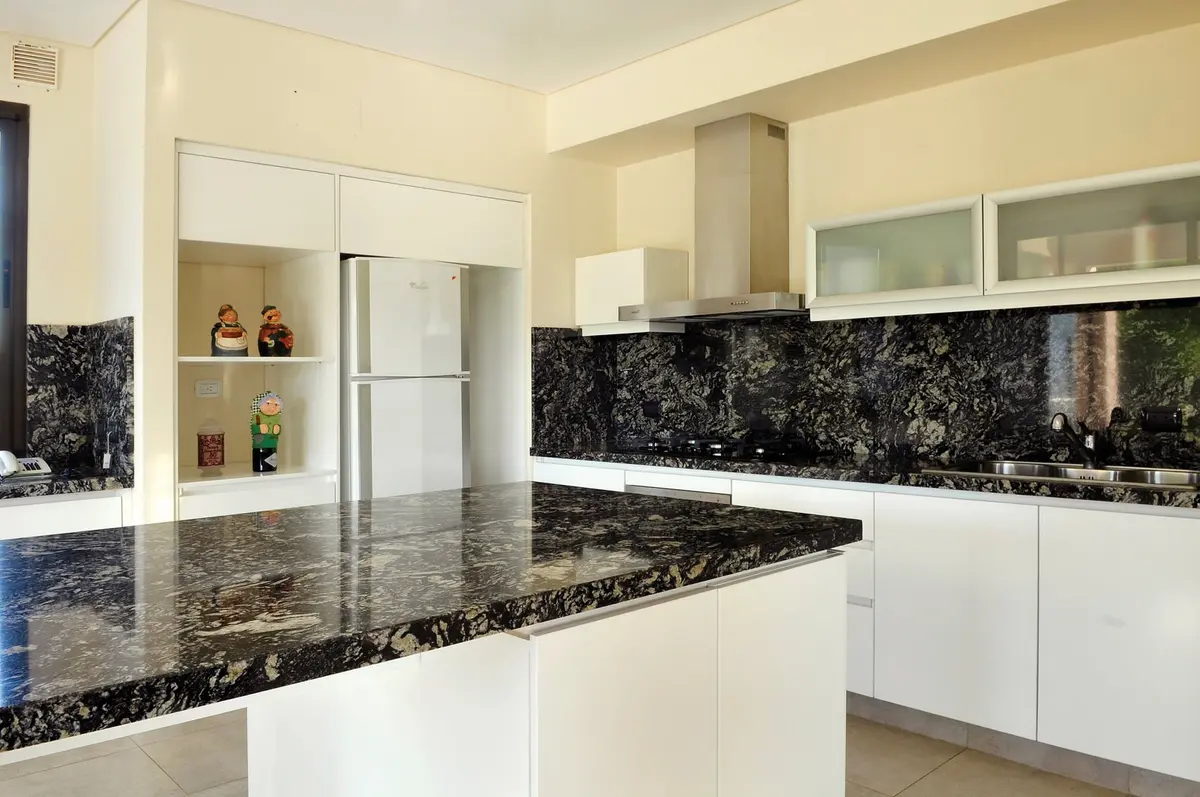 Cocina Con Isla Estilo Moderno con color predominante Beige del Proyecto Casa 6 por Parrado Arquitectura