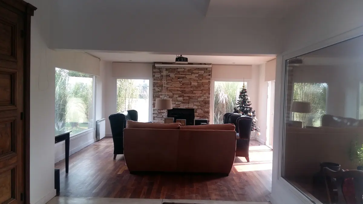 Living moderno con chimenea y árbol de Navidad — proyecto Casa Rumenco 3, por Estudio Arq. Carolina Peruzzo , en Mar del Plata