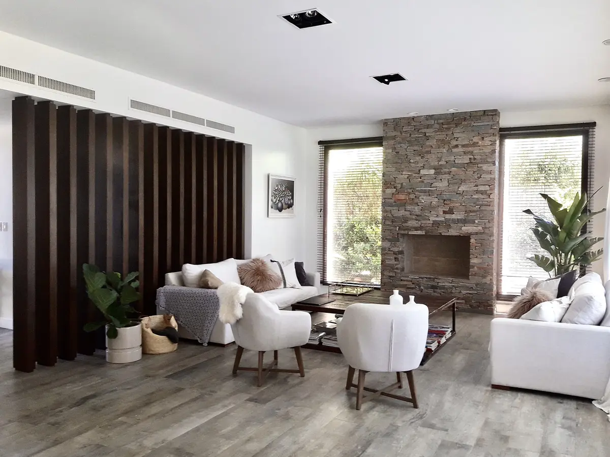 living moderno con cortinas negras, chimenea de ladrillo y sofás blancos — proyecto Golf Club Nordelta, por Marconi Silva Arquitectos, en Nordelta