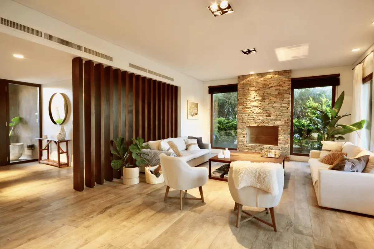 Living contemporáneo con ladrillo visto, ventanales y plantas naturales — proyecto Golf Club Nordelta, por Marconi Silva Arquitectos, en Nordelta