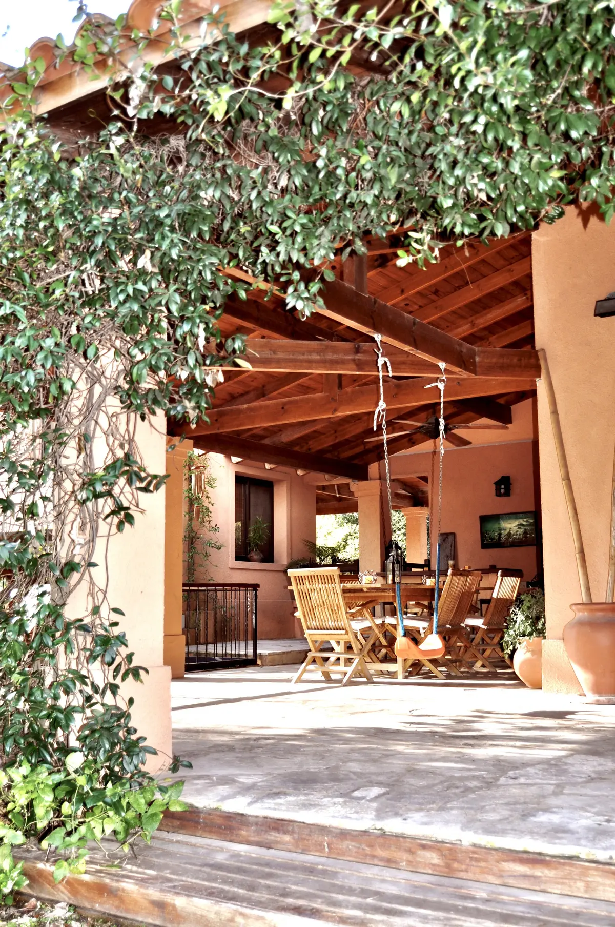 Patio cubierto con pérgola de madera y enredaderas naturales — proyecto La Retama, por Marconi Silva Arquitectos, en Manzanares