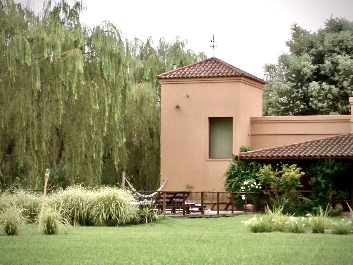 Casa terracota con jardín verde, pérgola y decoración mediterránea — proyecto La Retama, por Marconi Silva Arquitectos, en Manzanares