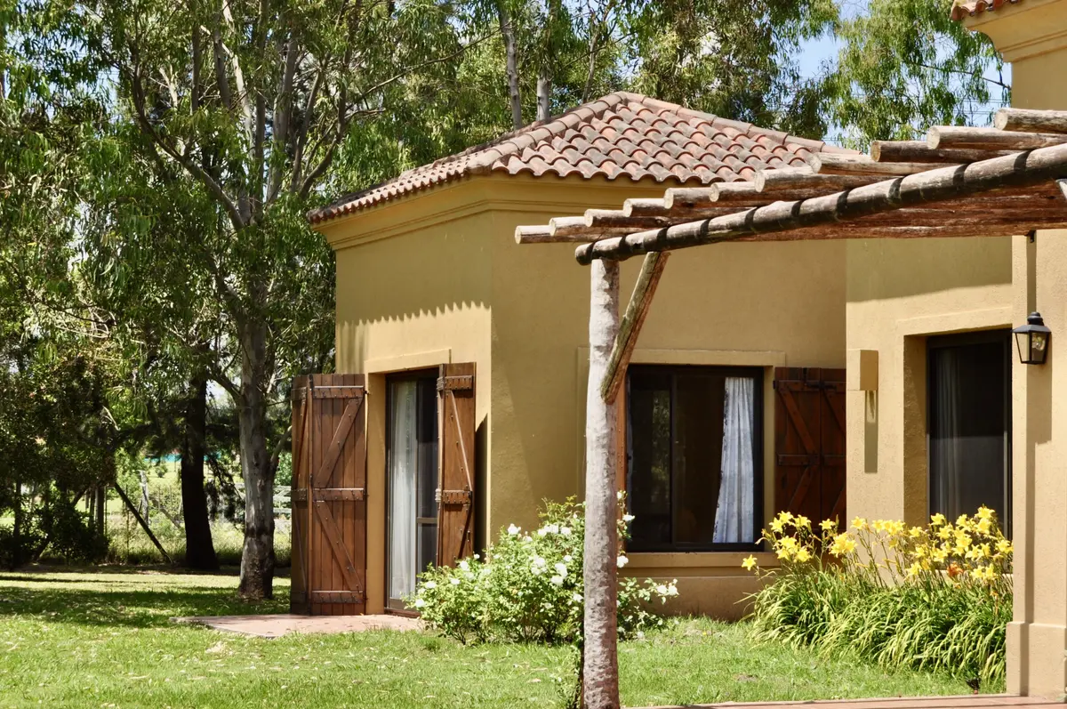 Casa estilo mediterráneo con pergola, jardín y fachada color ocre — proyecto La Retama 2, por Marconi Silva Arquitectos, en Manzanares