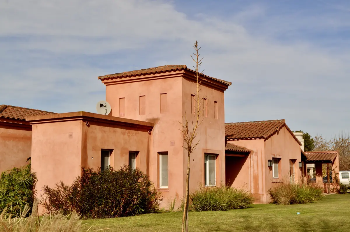 Fachada moderna de vivienda en tonos terracota con jardín — proyecto San Francisco 1, por Marconi Silva Arquitectos, en Manzanares