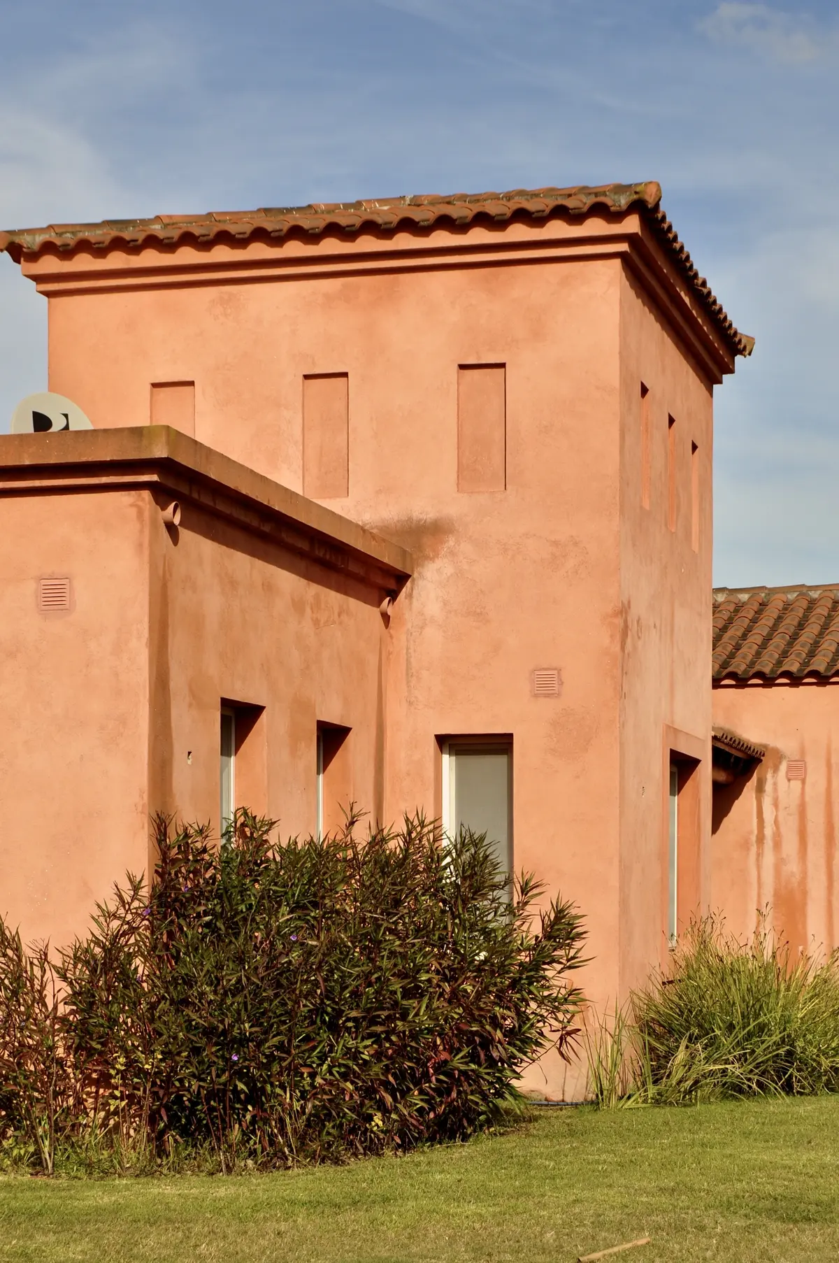 Casa terracota estilo mediterráneo con jardín y cielo azul — proyecto San Francisco 1, por Marconi Silva Arquitectos, en Manzanares