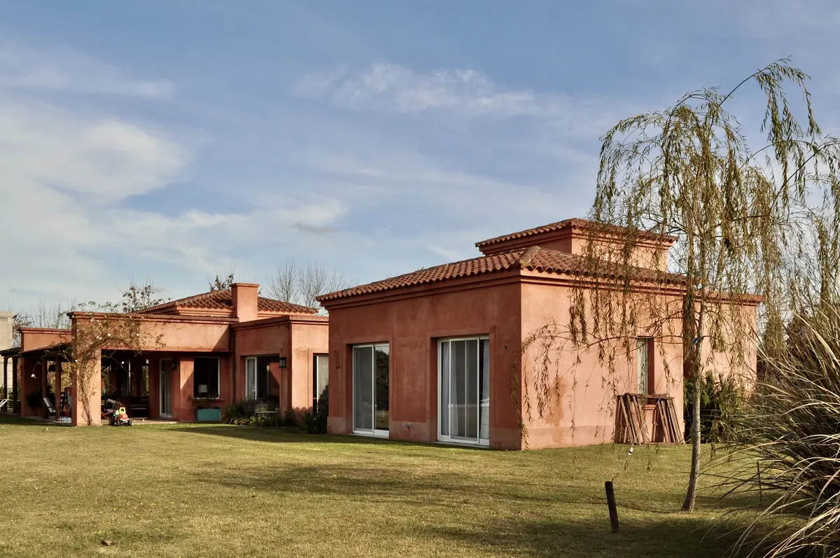 Casa de ladrillo terracota con galeria, jardin y sauce llorón — proyecto San Francisco 1, por Marconi Silva Arquitectos, en Manzanares