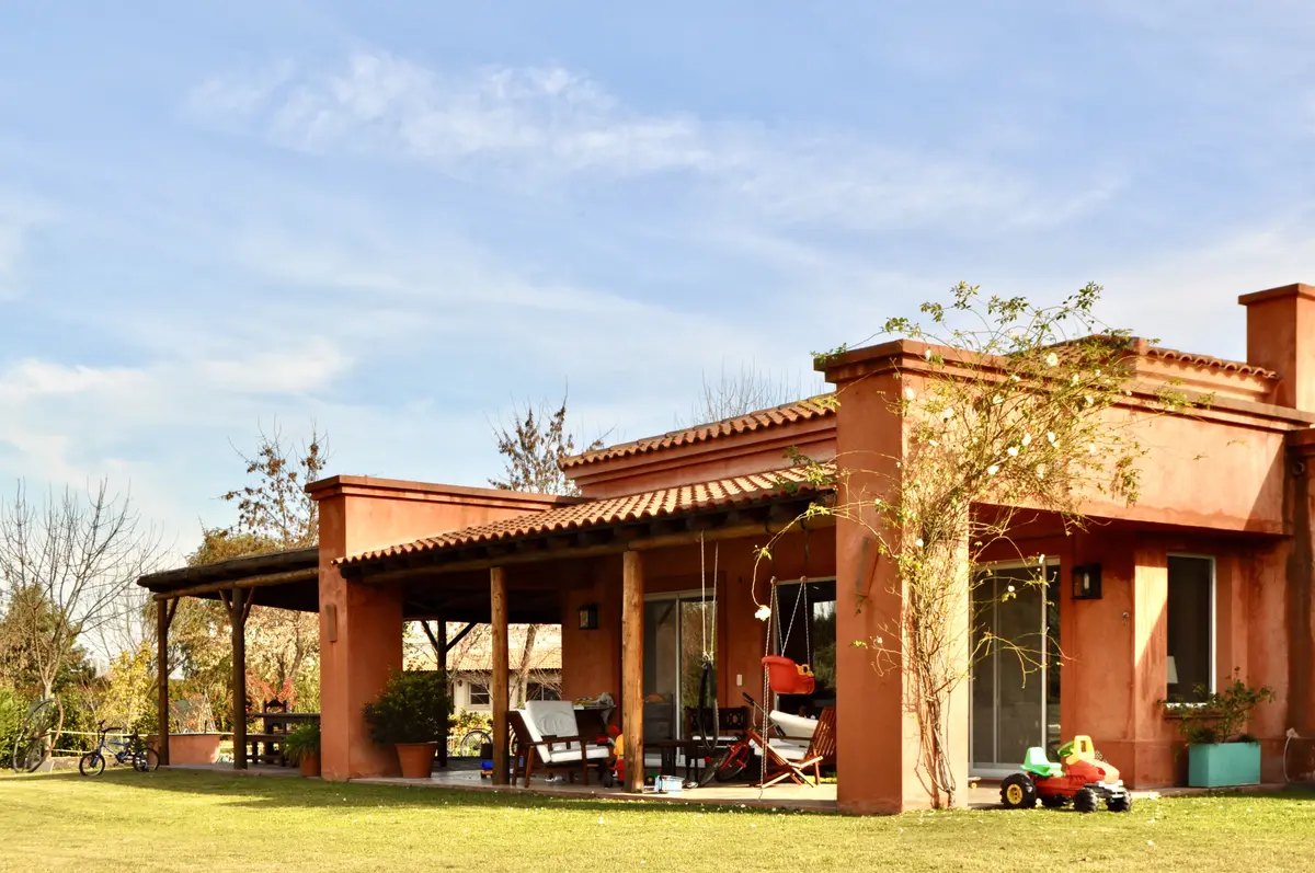 Casa campo con galería cubierta ladrillo visto y jardín verde — proyecto San Francisco 1, por Marconi Silva Arquitectos, en Manzanares