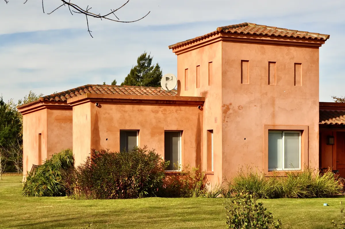 Casa terracota con torre lateral y jardín delantero, estilo mediterráneo — proyecto San Francisco 1, por Marconi Silva Arquitectos, en Manzanares