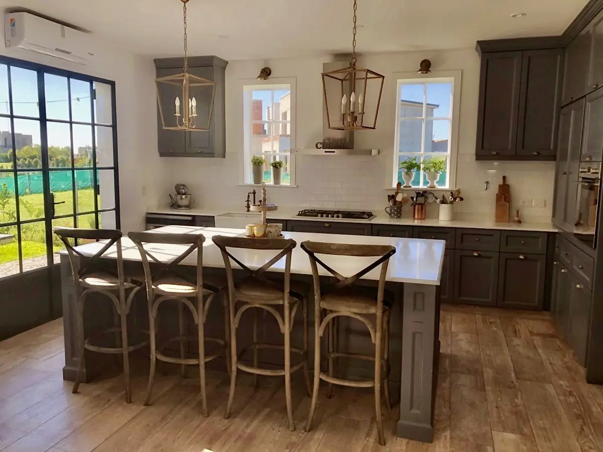 Cocina moderna con isla central y banquetas altas de madera — proyecto San Matías, por Marconi Silva Arquitectos, en Belén de Escobar