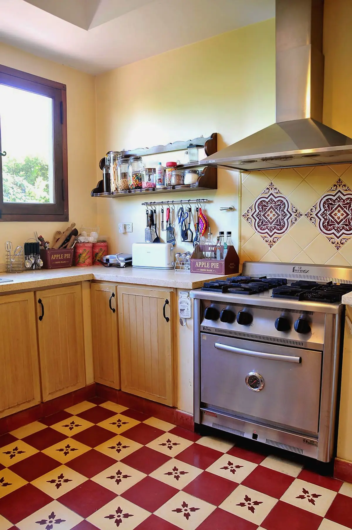 Cozinha rústica com piso xadrez vermelho e forno de aço — projeto Valle Claro, por Marconi Silva Arquitectos, em Benavidez