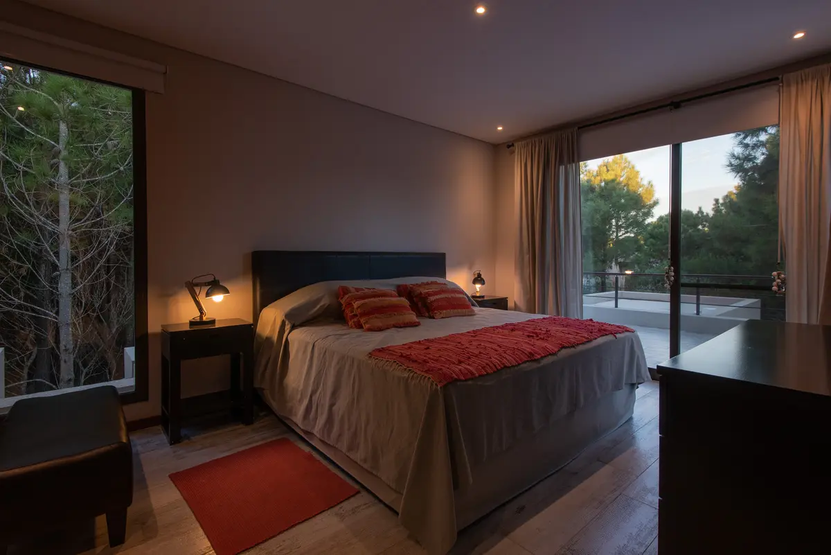Quarto moderno com vista para floresta e iluminação quente — projeto Costa Esmeralda 1, por Arquitecto Caceres, em Costa Esmeralda