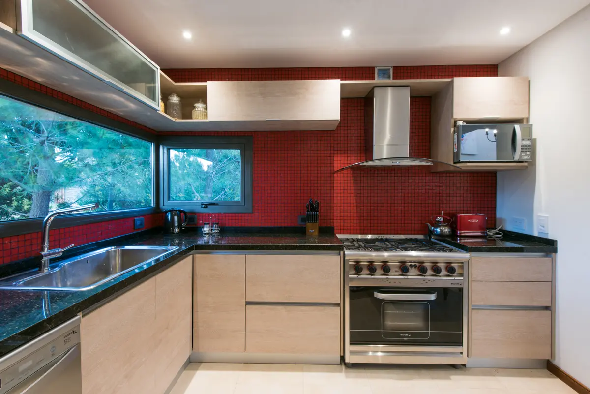 Cozinha moderna com azulejo vermelho e janela panorâmica — projeto Costa Esmeralda 2, por Arquitecto Caceres, em Costa Esmeralda