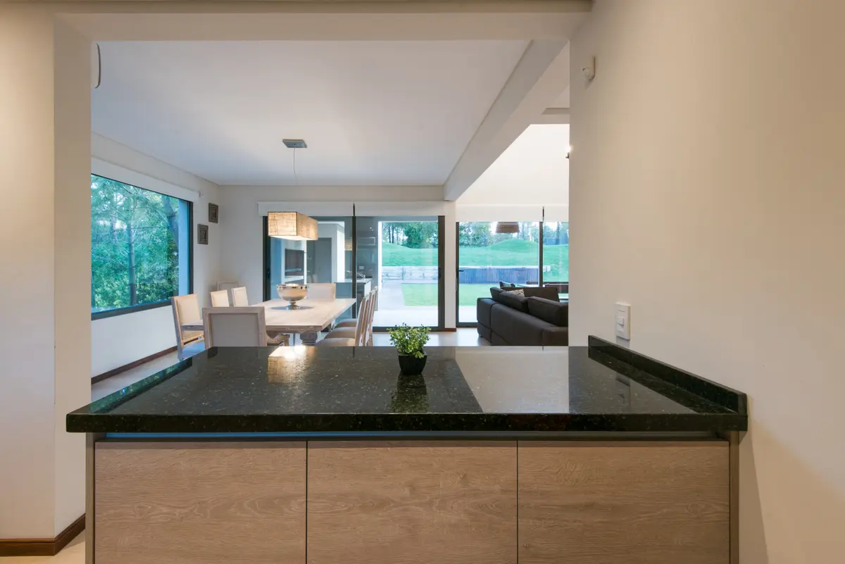 Cocina moderna con isla, comedor y living integrados, vista amplia — proyecto Costa Esmeralda 2, por Arquitecto Caceres, en Costa Esmeralda