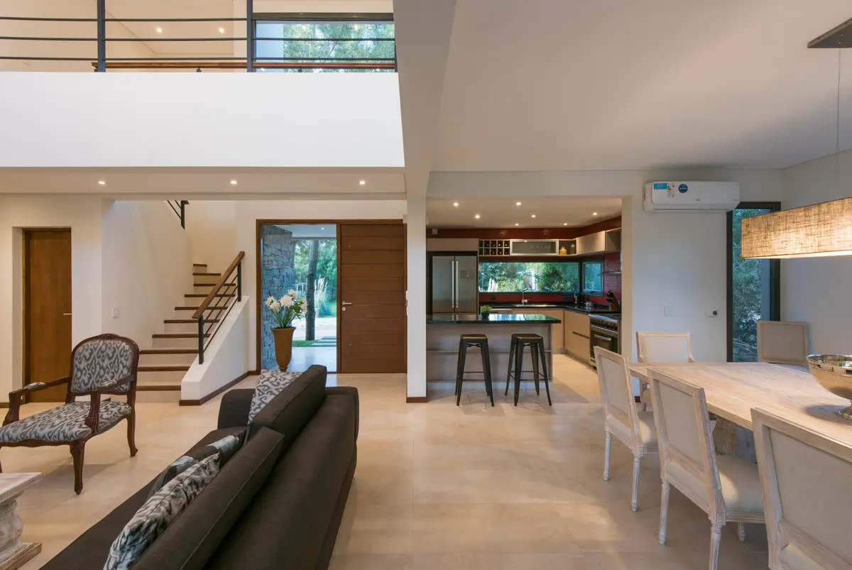 Living comedor moderno con cocina integrada y escalera flotante — proyecto Costa Esmeralda 2, por Arquitecto Caceres, en Costa Esmeralda