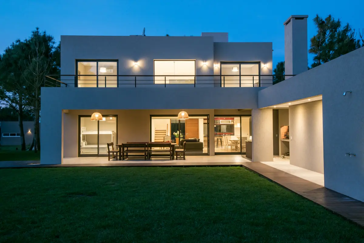 Fachada moderna de casa com pátio e luzes quentes — projeto Costa Esmeralda 2, por Arquitecto Caceres, em Costa Esmeralda