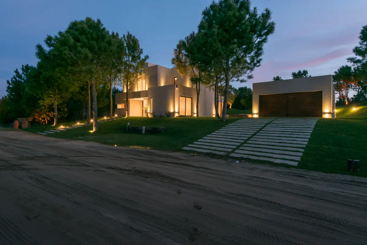 casa moderna branca com iluminação integrada e vegetação exuberante — projeto Costa Esmeralda 2, por Arquitecto Caceres, em Costa Esmeralda