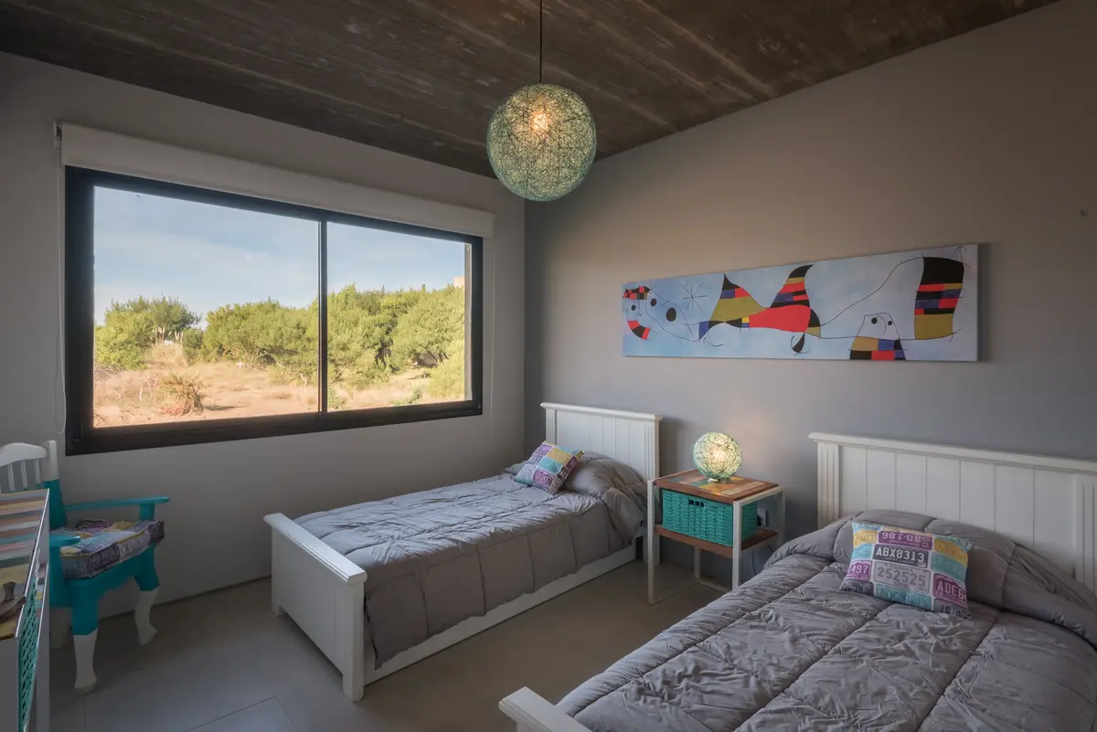 Quarto moderno com vista para o campo e teto de concreto — projeto Costa Esmeralda 3, por Arquitecto Caceres, em Costa Esmeralda