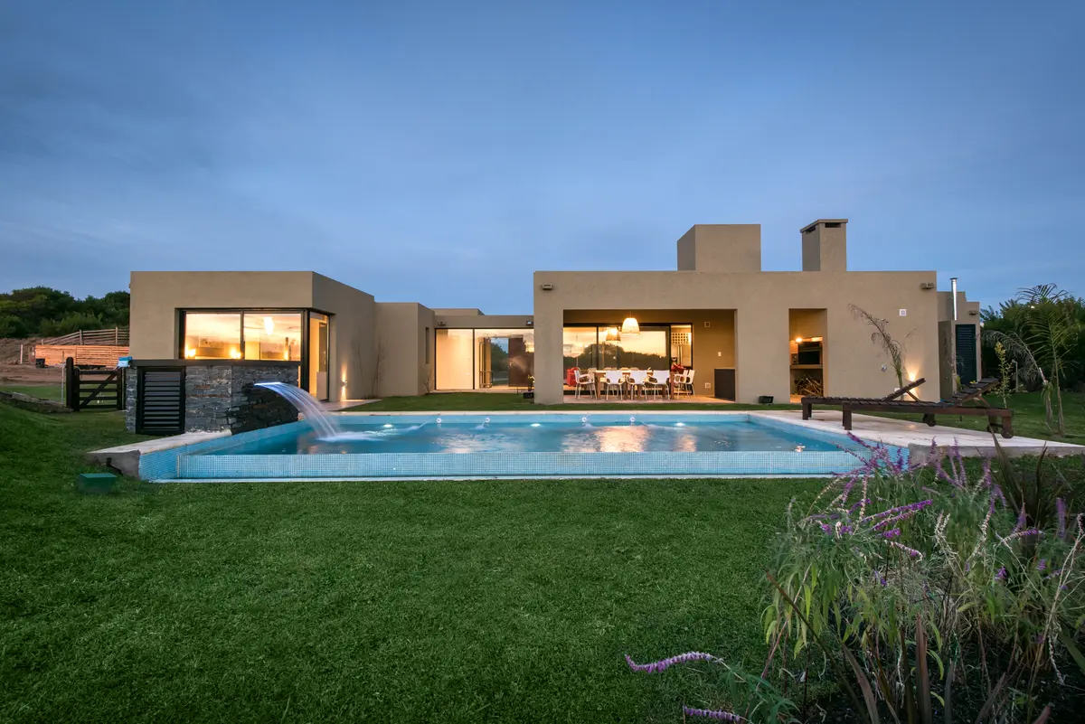 Casa moderna com piscina e pátio gramado — projeto Costa Esmeralda 3, por Arquitecto Caceres, em Costa Esmeralda