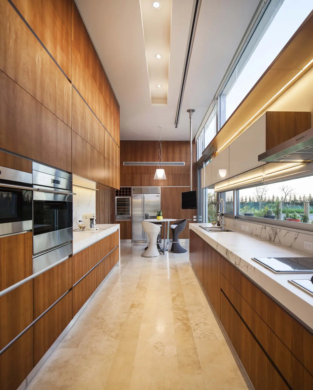 Cocina moderna con paneles de madera, ventanales y isla — proyecto Casa Pez, por Barrionuevo Arquitects, en B1648 Tigre