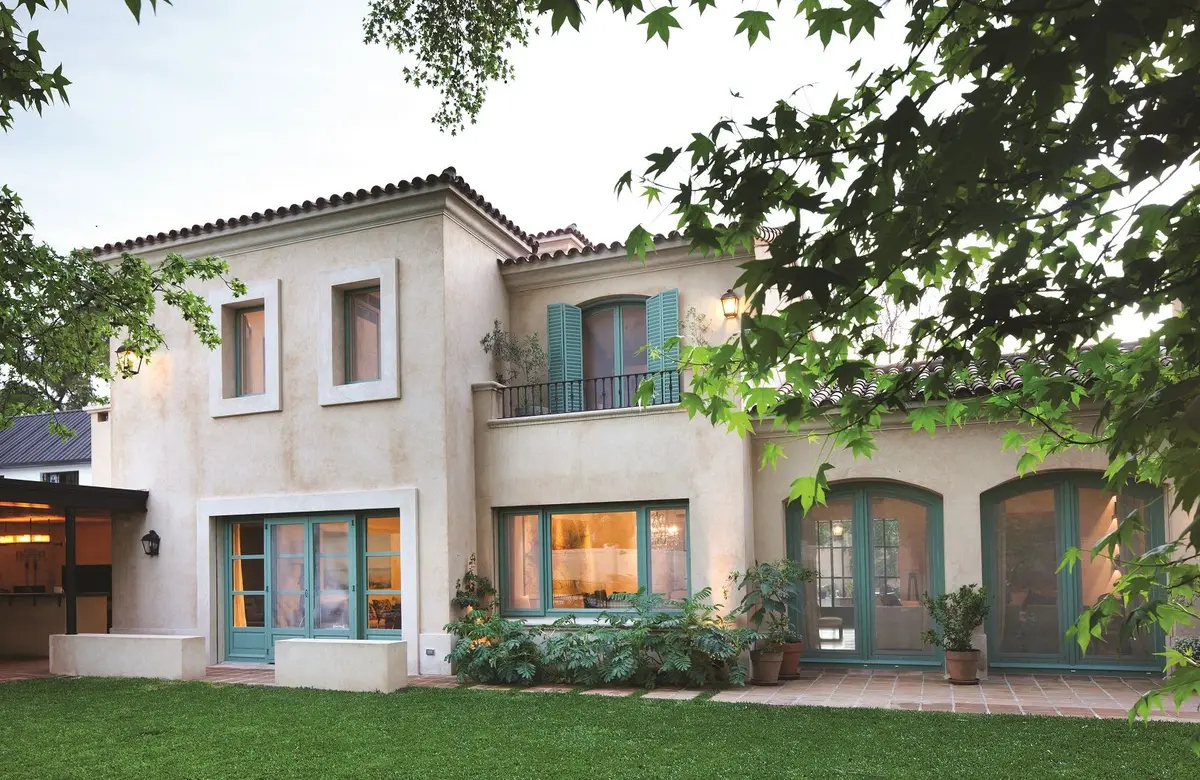 Fachada moderna mediterrânea com vegetação exuberante e arcos — projeto Un Patio Interior, por Ricardo Pereyra Iraola