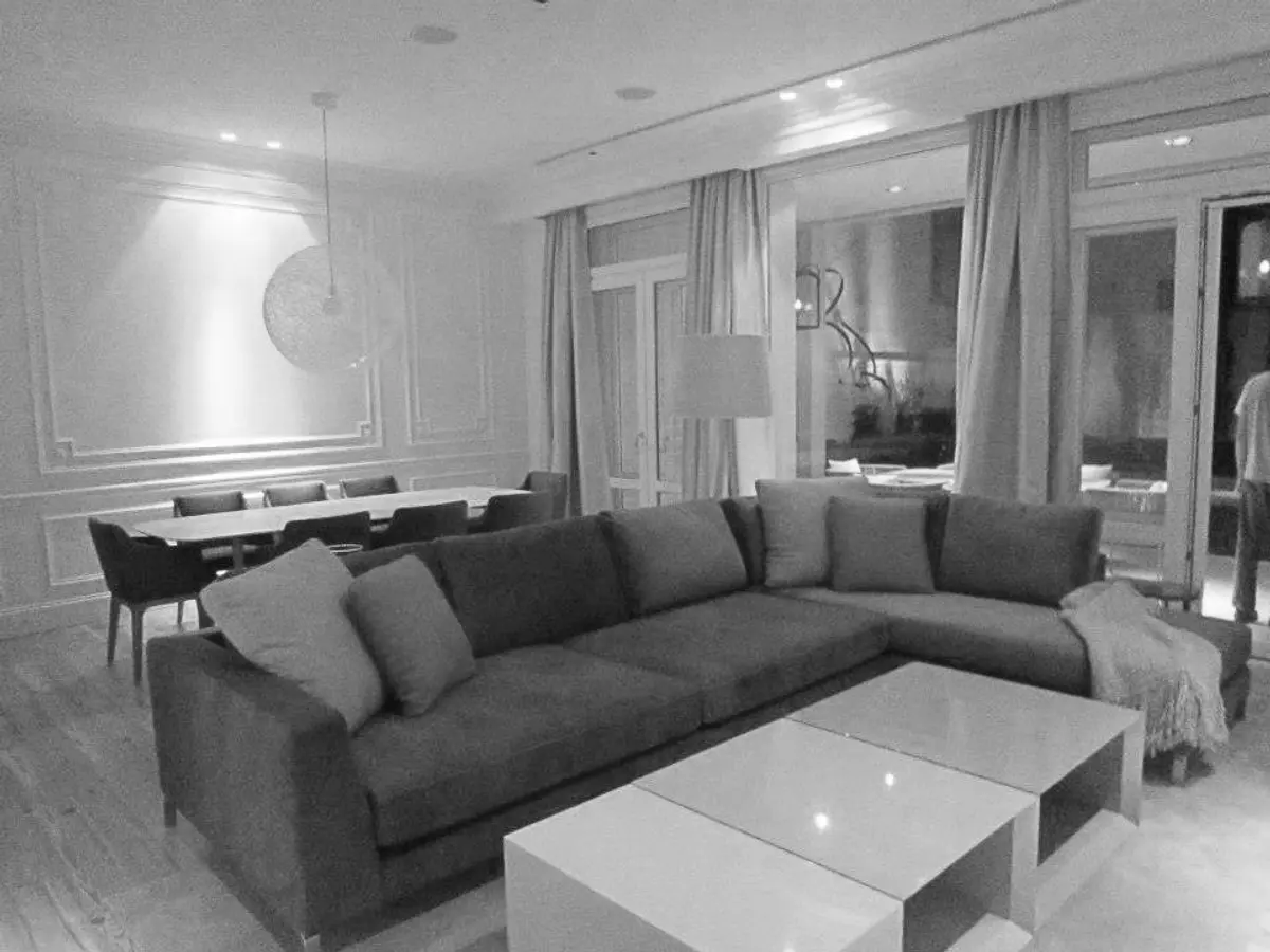Living moderno con sofá seccional gris y ventanales amplios — proyecto Reforma Belgrano R, por Estudio Moreto Bensusan, en Belgrano R
