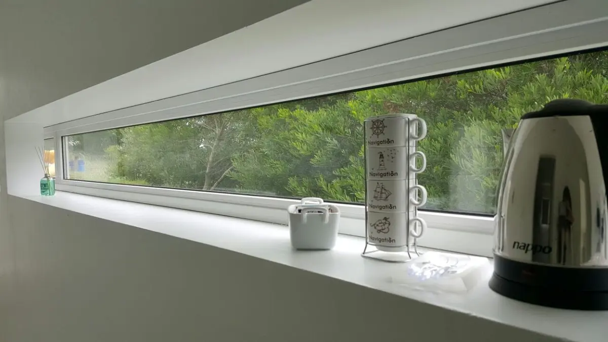 Cocina moderna con ventana panorámica y vista al bosque — proyecto Costa Esmeralda, por Cuello Selva, en Costa Esmeralda