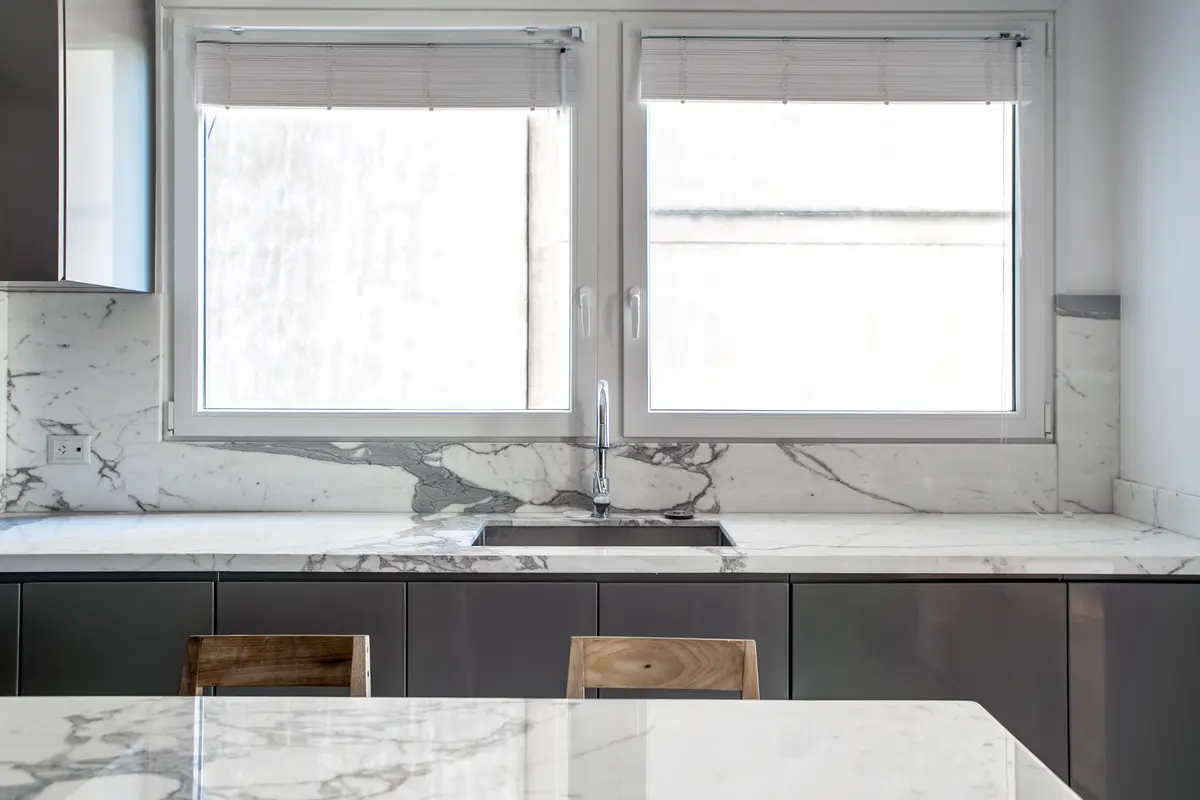 Cocina moderna con mesada de mármol y ventanales amplios — proyecto Lafinur, por Estudio Magrane, en CABA