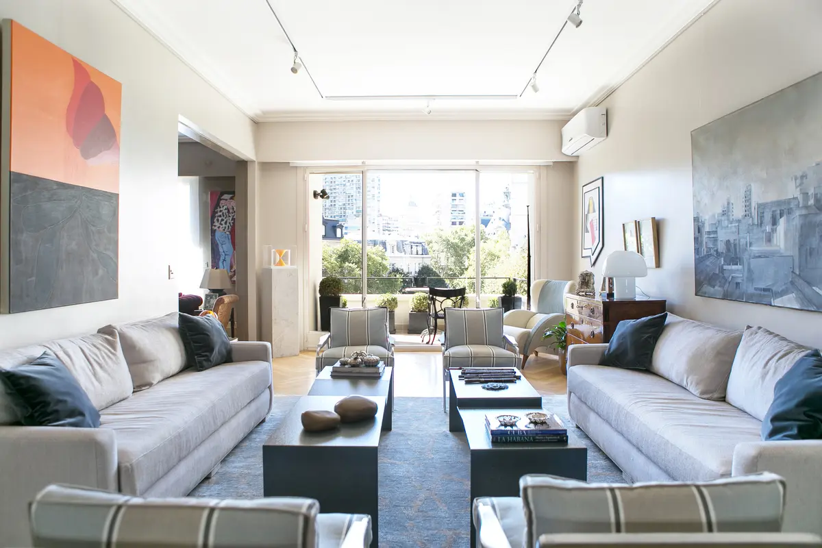 living moderno con sillones blancos y mesa ratona de madera — proyecto Libertad, por Estudio Magrane, en CABA