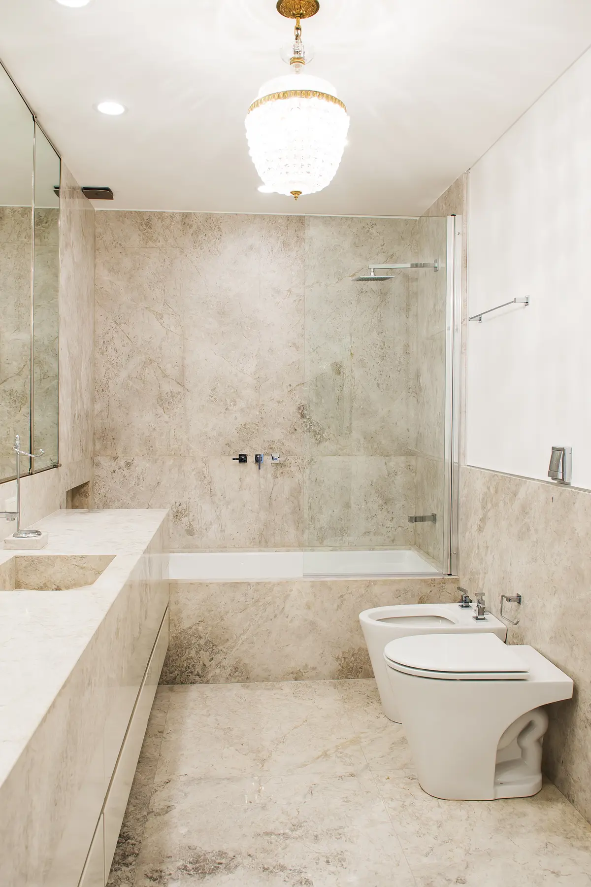 Baño moderno con revestimientos y mesada de mármol beige — proyecto Libertad, por Estudio Magrane, en CABA