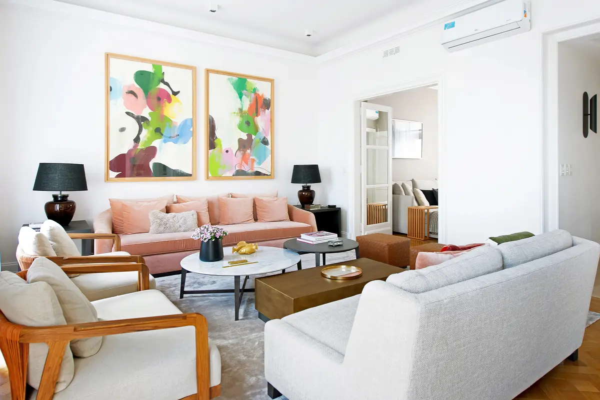 Living luminoso y moderno con sillones de cuero y arte abstracto — proyecto Libertador y Salguero, por Estudio Magrane, en CABA
