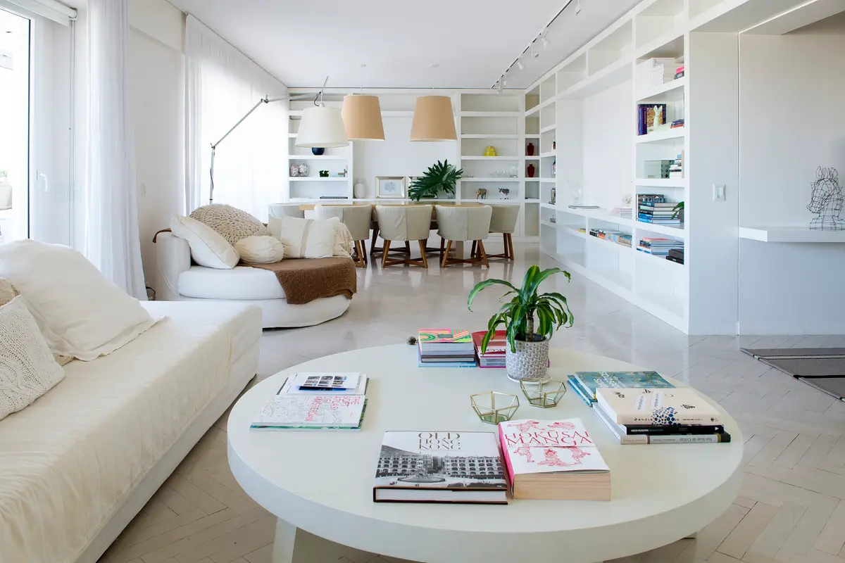 Amplio living-comedor moderno con estanterías blancas y ventanales luminosos — proyecto San Martín de Tours, por Estudio Magrane, en CABA