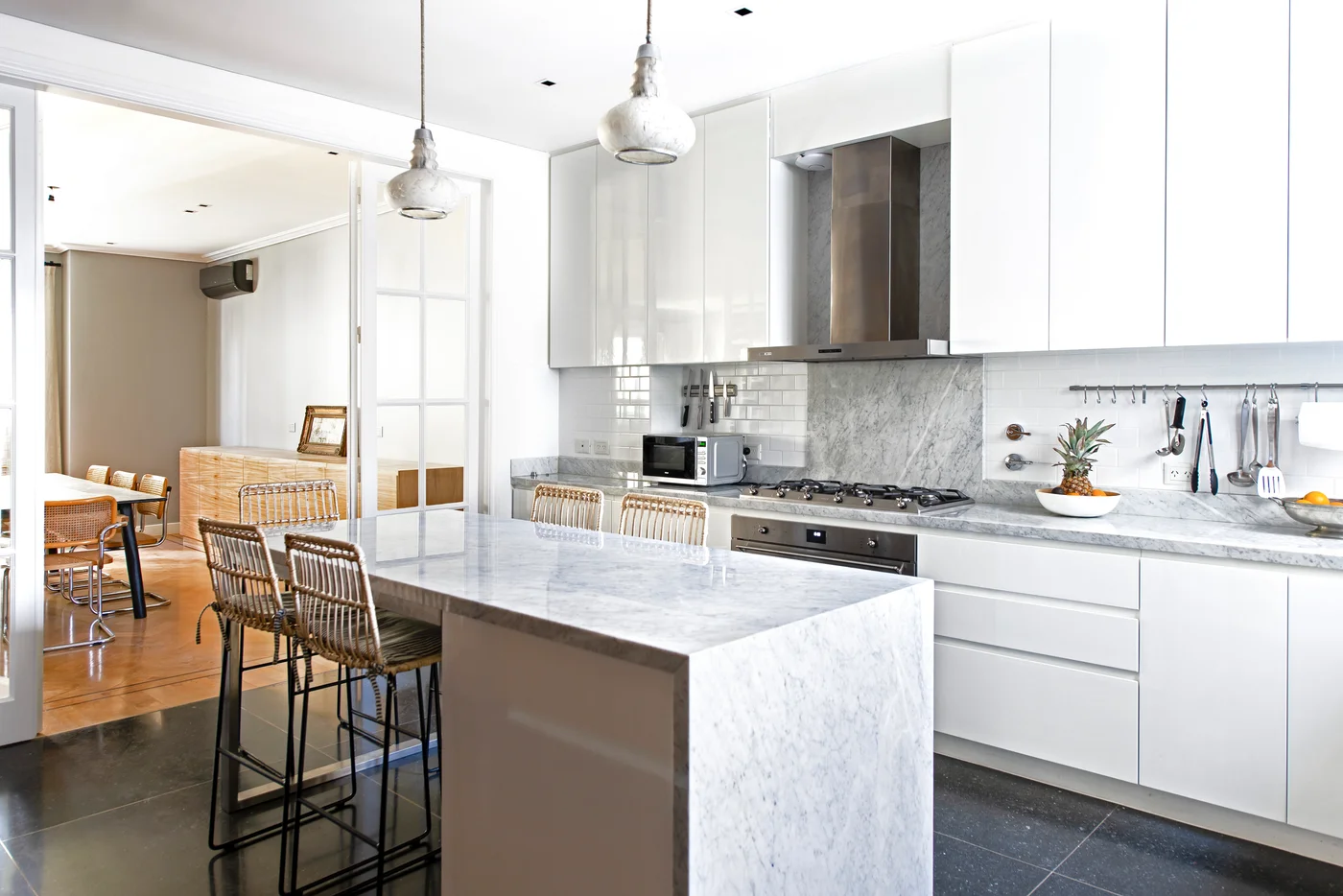 Cocina moderna con isla central, mesada de mármol y ventanal al comedor