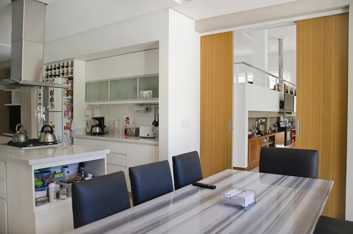 Cocina moderna abierta con isla y comedor, revestimientos de madera — proyecto Casa  en San Isidro, por GEN STUDIO  COMOTTO - SOMMER , en San Isidro