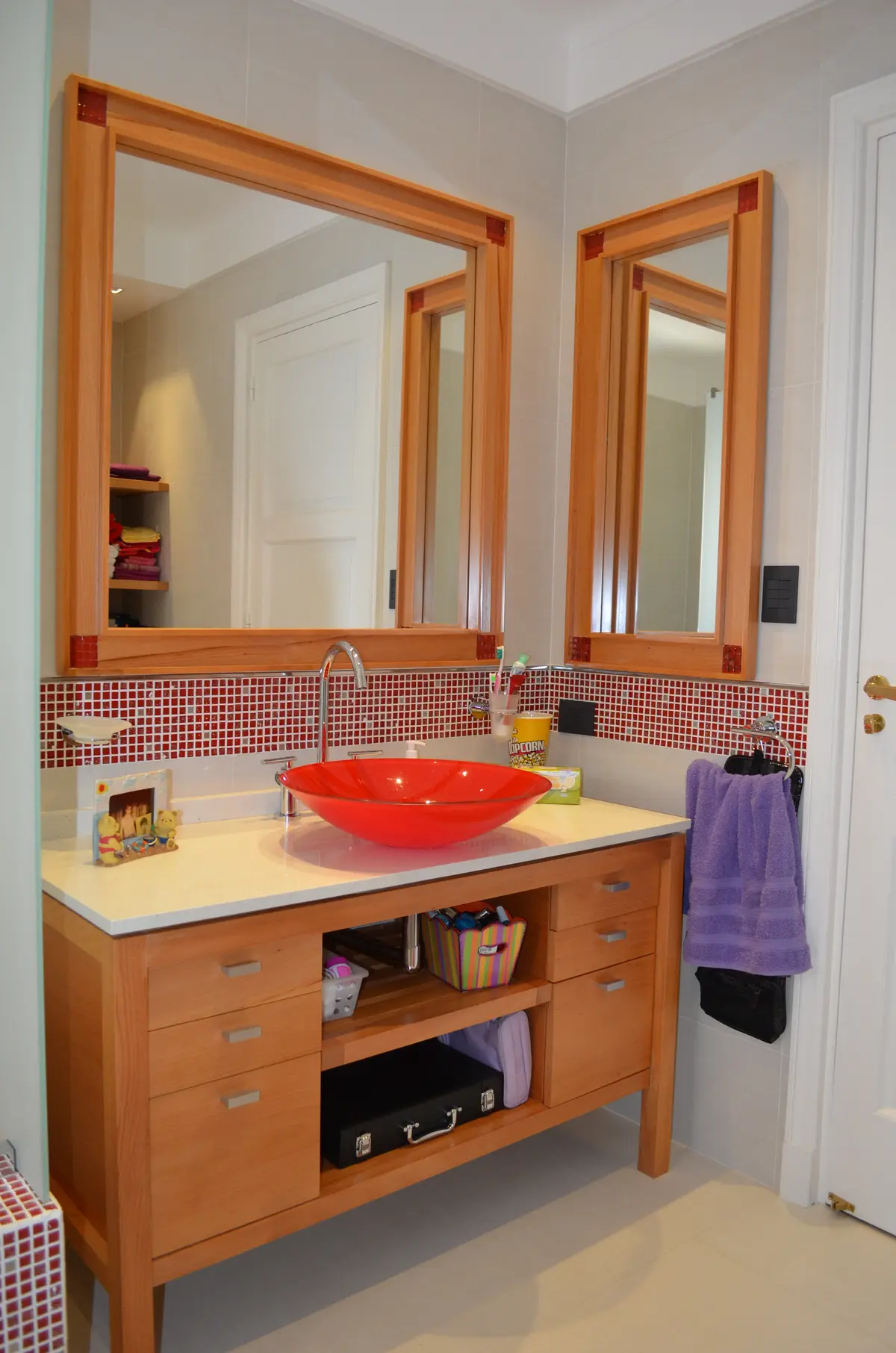 Baño moderno con lavabo rojo y mueble de madera — proyecto Casa en Barrio El Jockey - San Isidro, por GEN STUDIO  COMOTTO - SOMMER , en San Isidro