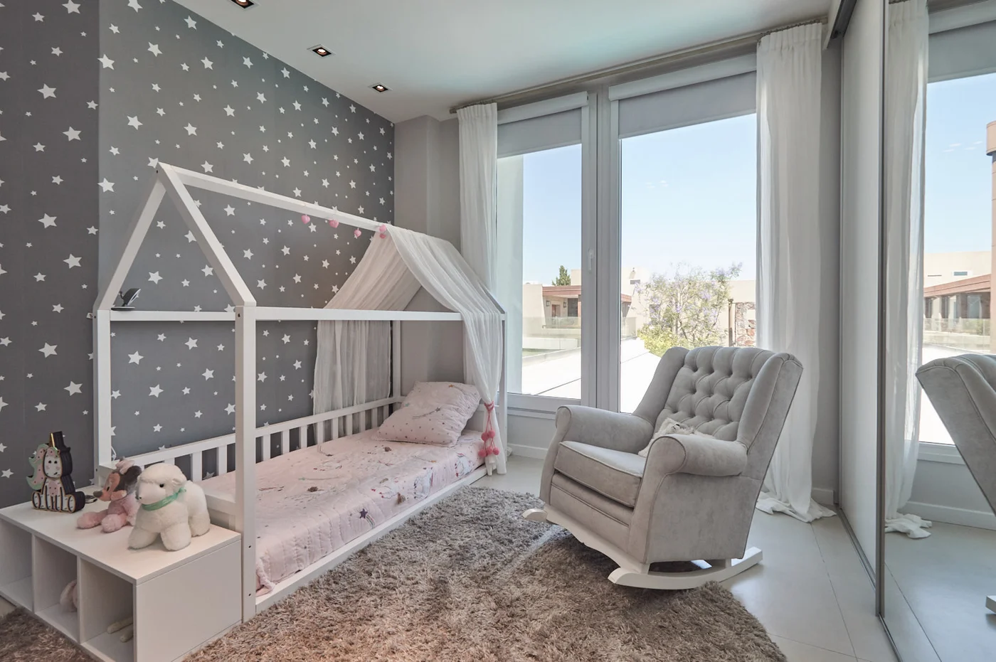 Dormitorio infantil moderno con cama casita y sillón