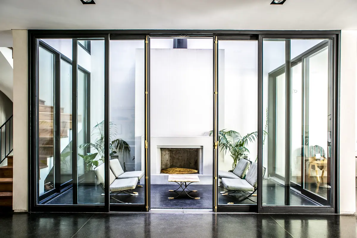 Sala moderna com grandes janelas de correr e lareira — projeto Belgrano, por Estudio Magrane, em Belgrano